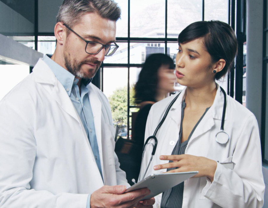 Nurse practitioner and physician assistant reviewing clinical information together in a healthcare setting, representing collaboration and job evaluation