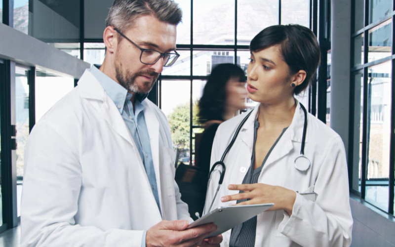 Nurse practitioner and physician assistant reviewing clinical information together in a healthcare setting, representing collaboration and job evaluation